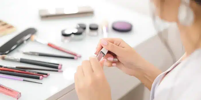 Gouttes de sérum sur une main devant une coiffeuse en plein jour