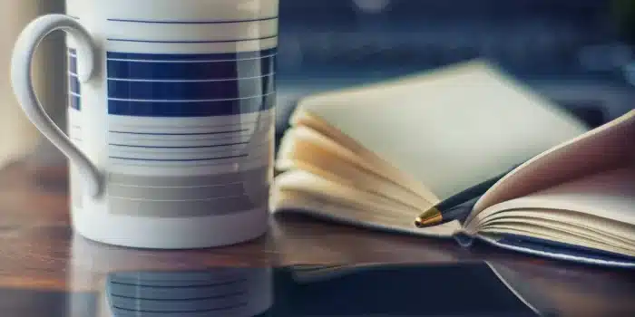 Coin d'un salon lumineux avec journal, stylo et tasse au soleil