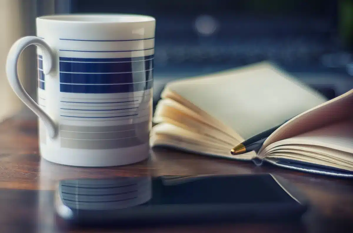 Coin d'un salon lumineux avec journal, stylo et tasse au soleil