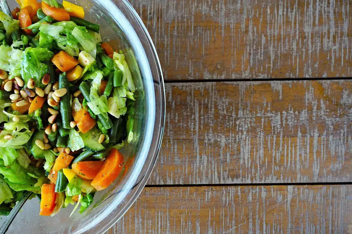 Bol de vinaigrette au sésame versé sur une salade