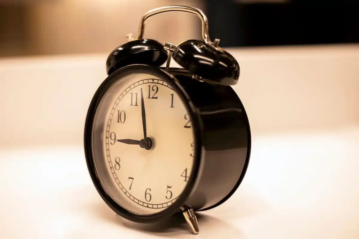 Montre près d'une assiette et d'un verre, évoquant la fenêtre 16/8 du jeûne intermittent