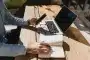 Smartphone posé sur un rebord de fenêtre avec pièces de réparation et carnet, lumière du jour