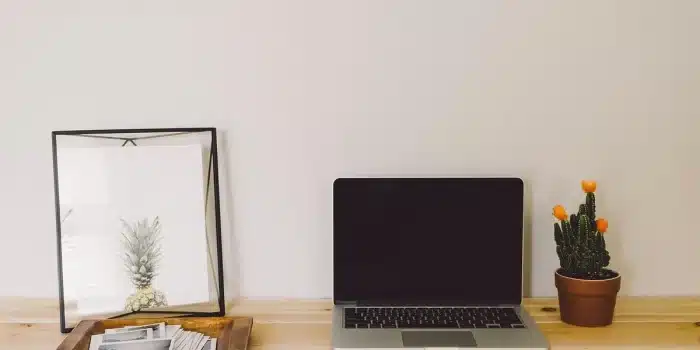 Bureau de maison en plein jour avec un carnet, un ordinateur fermé et une tasse de thé
