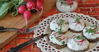 Bocal de cancoillotte versé sur une tranche de pain complet dans une cuisine en journée