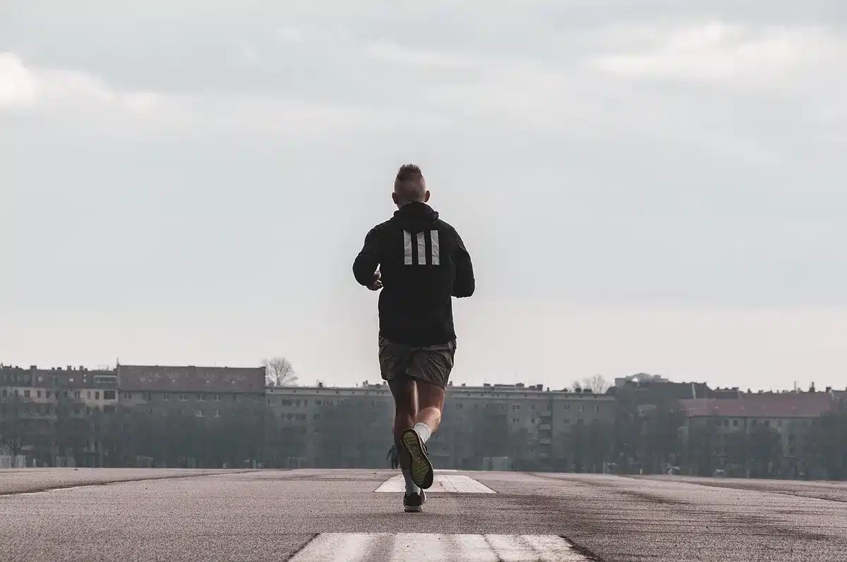 Deux sportifs en relais lors d'un entraînement cardio en extérieur