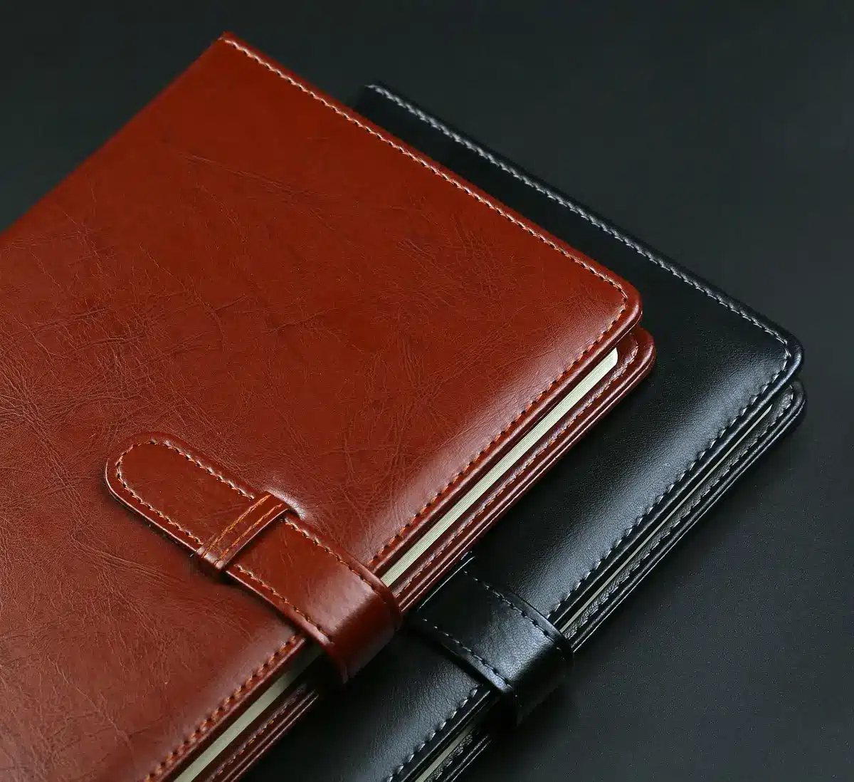 Carnet de notes et téléphone posés côte à côte sur un bureau en plein jour